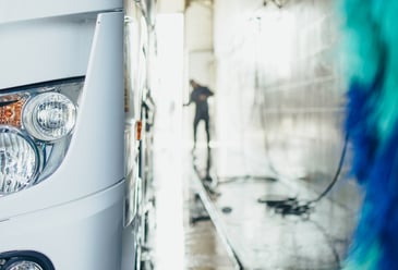 Truck being washed at an automated vehicle wash system facility.
