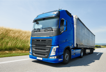 A blue lorry on the road that can be washed with a bus wash system.