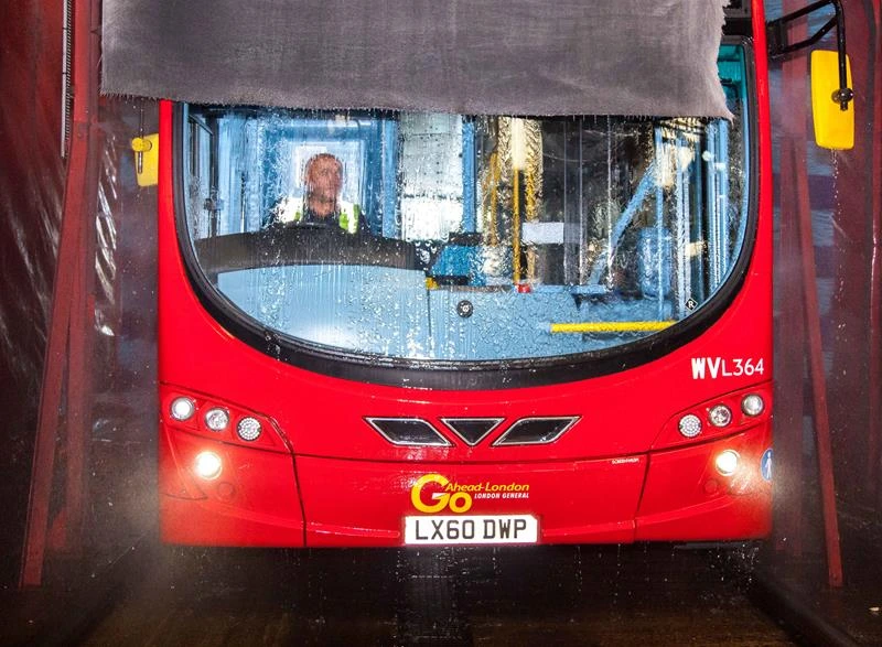 A bus being washed in a bus wash system