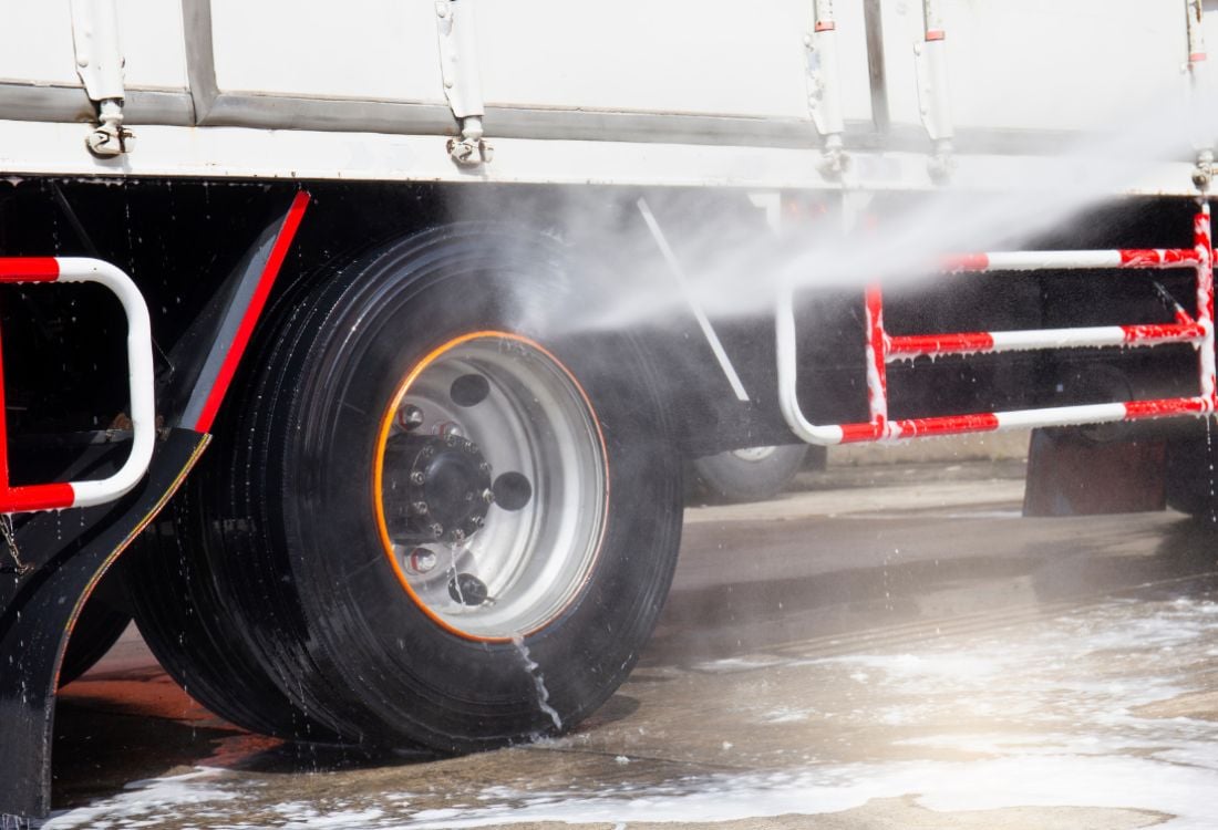 A truck’s wheel getting washed using a commercial truck washing system to help save time and money.