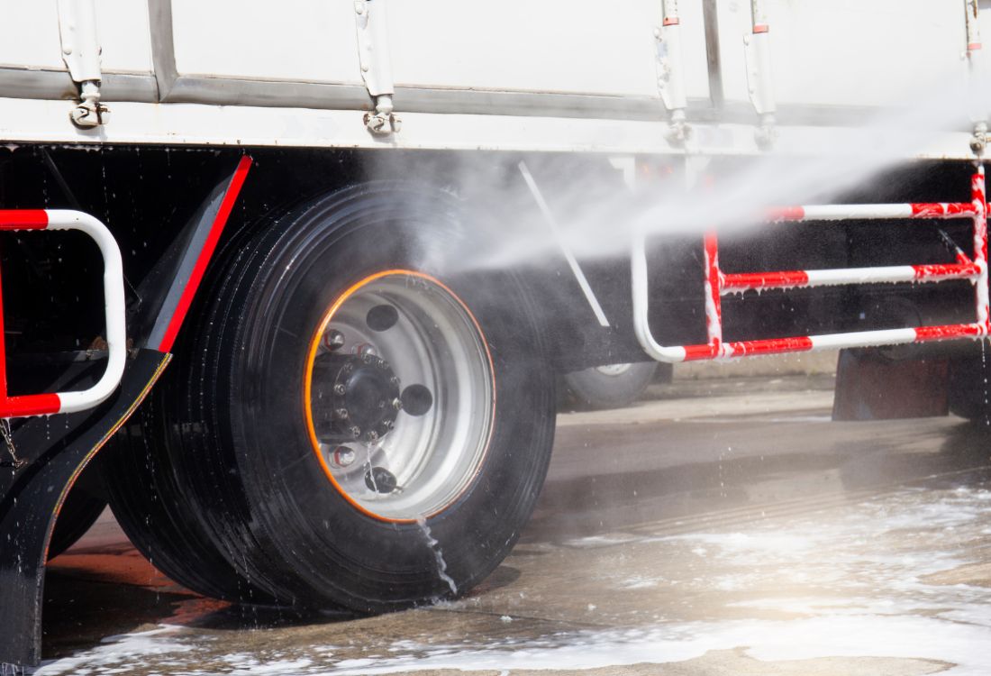  A truck’s wheel getting washed using a commercial truck washing system to help save time and money.