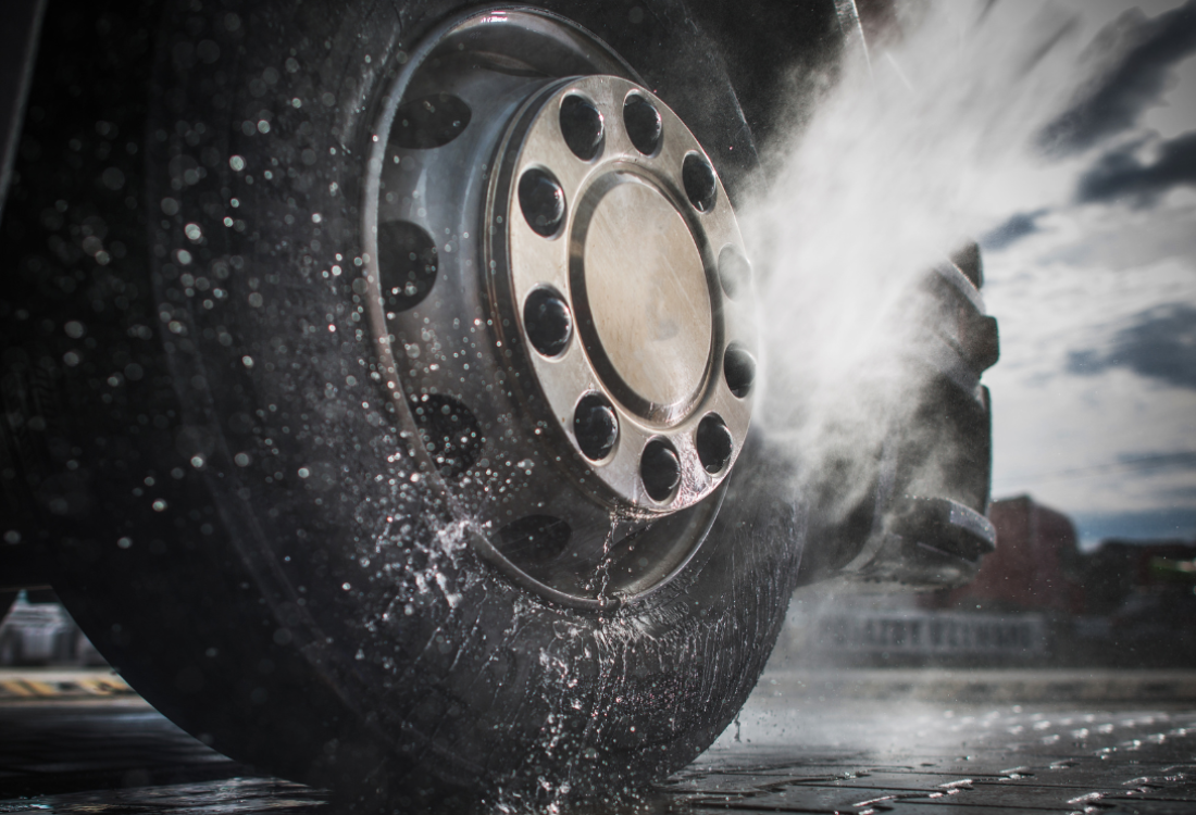  A wheel of a truck getting cleaned using a vehicle wheel wash system